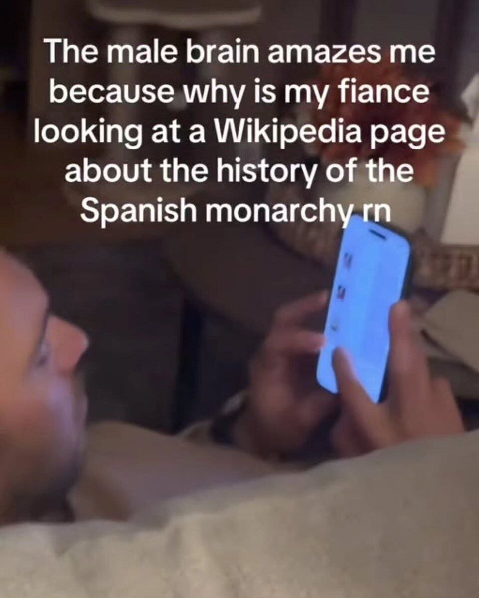 Man scrolling Wikipedia about Spanish monarchy at night