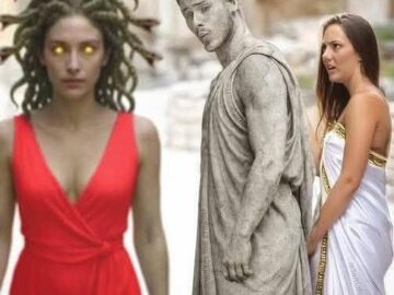 Woman in red dress standing next to a statue of Medusa